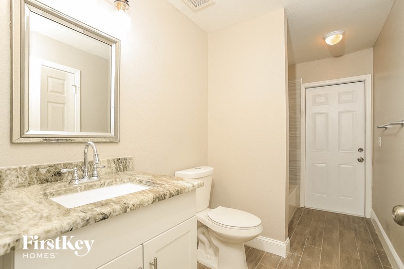 a bathroom with a toilet and a sink and a mirror