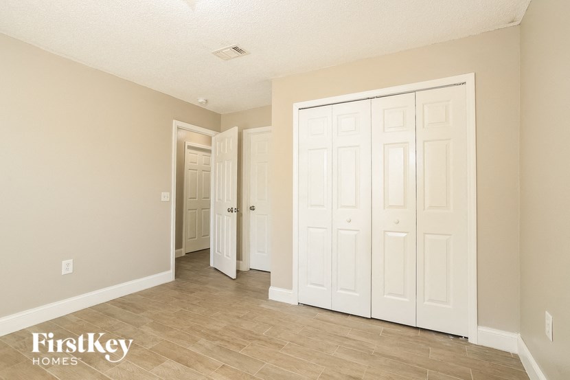 the living room and hallway of a house with white doors