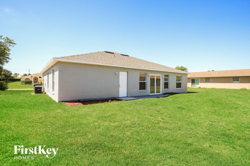 a small white house with a yard and grass