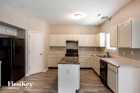 A kitchen with white cabinets and appliances.