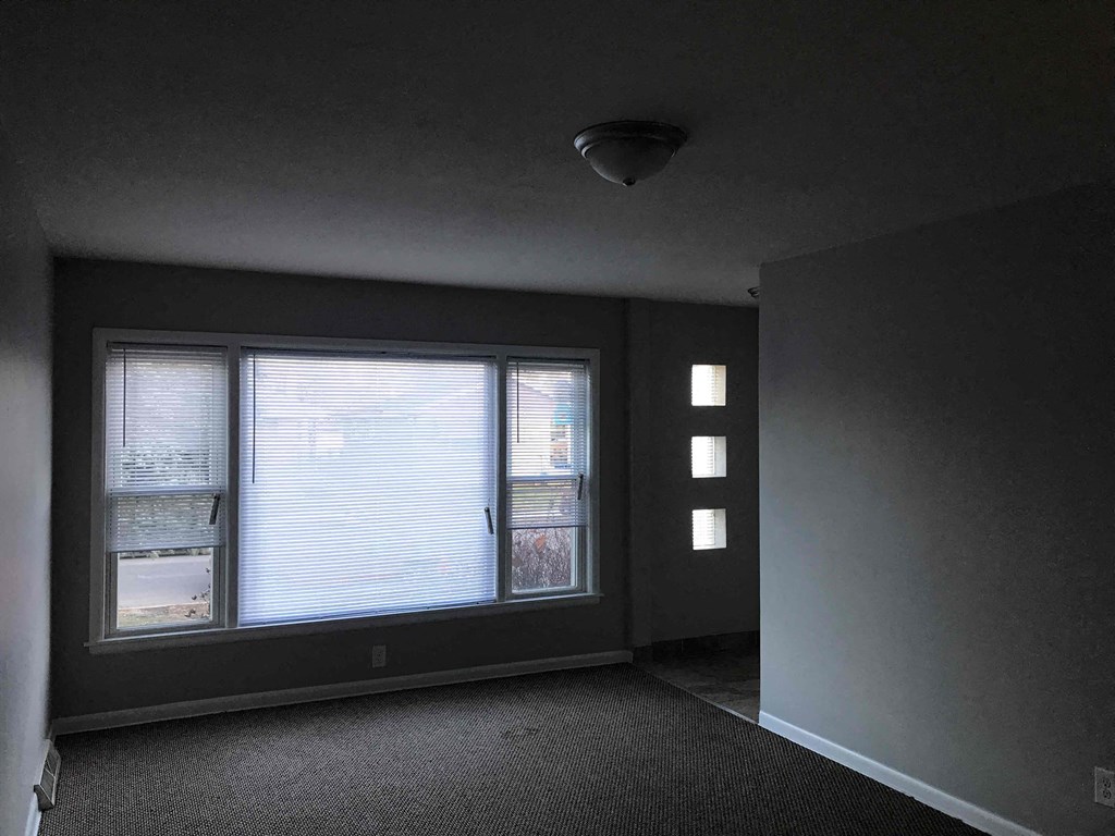a dark room with a window and a light on the ceiling