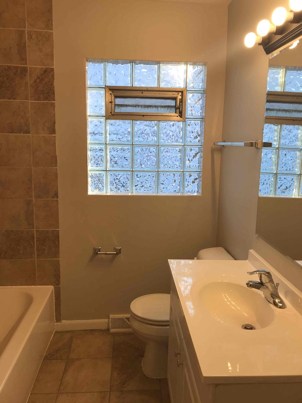 a bathroom with a sink and a toilet and a window