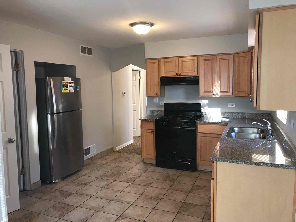 a kitchen with black appliances and wooden cabinets