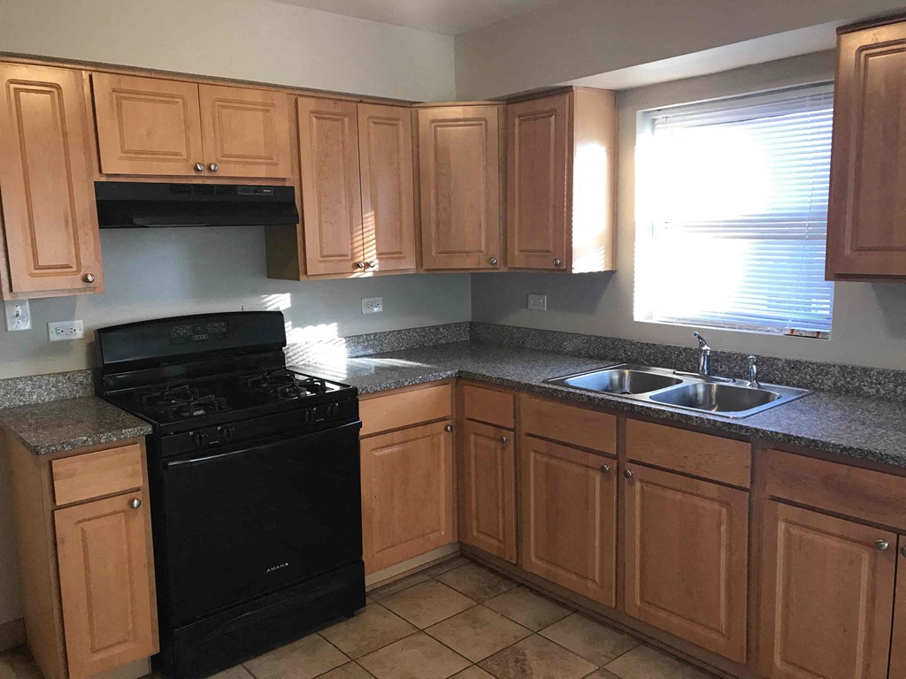 a kitchen with wooden cabinets and black appliances