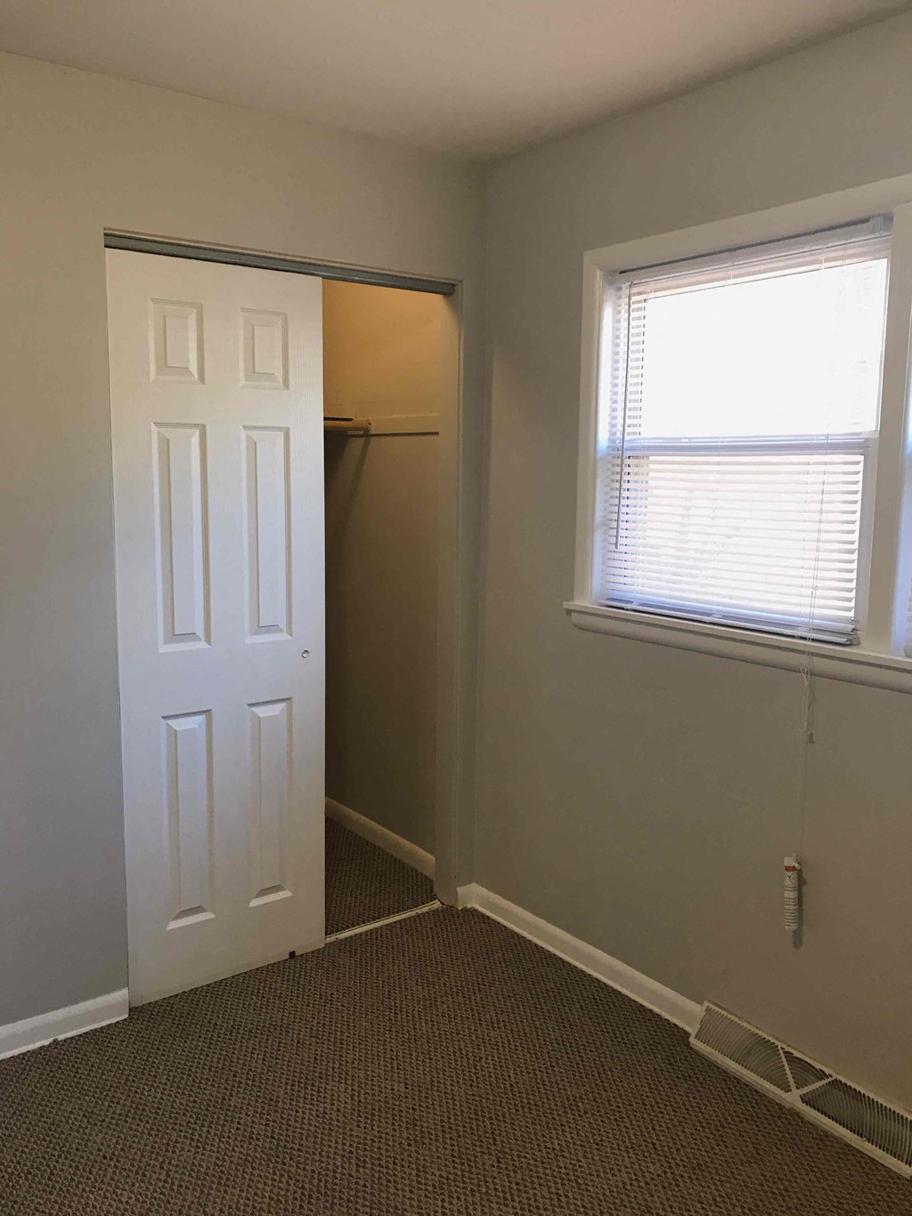 a room with a closet and a window and a white door