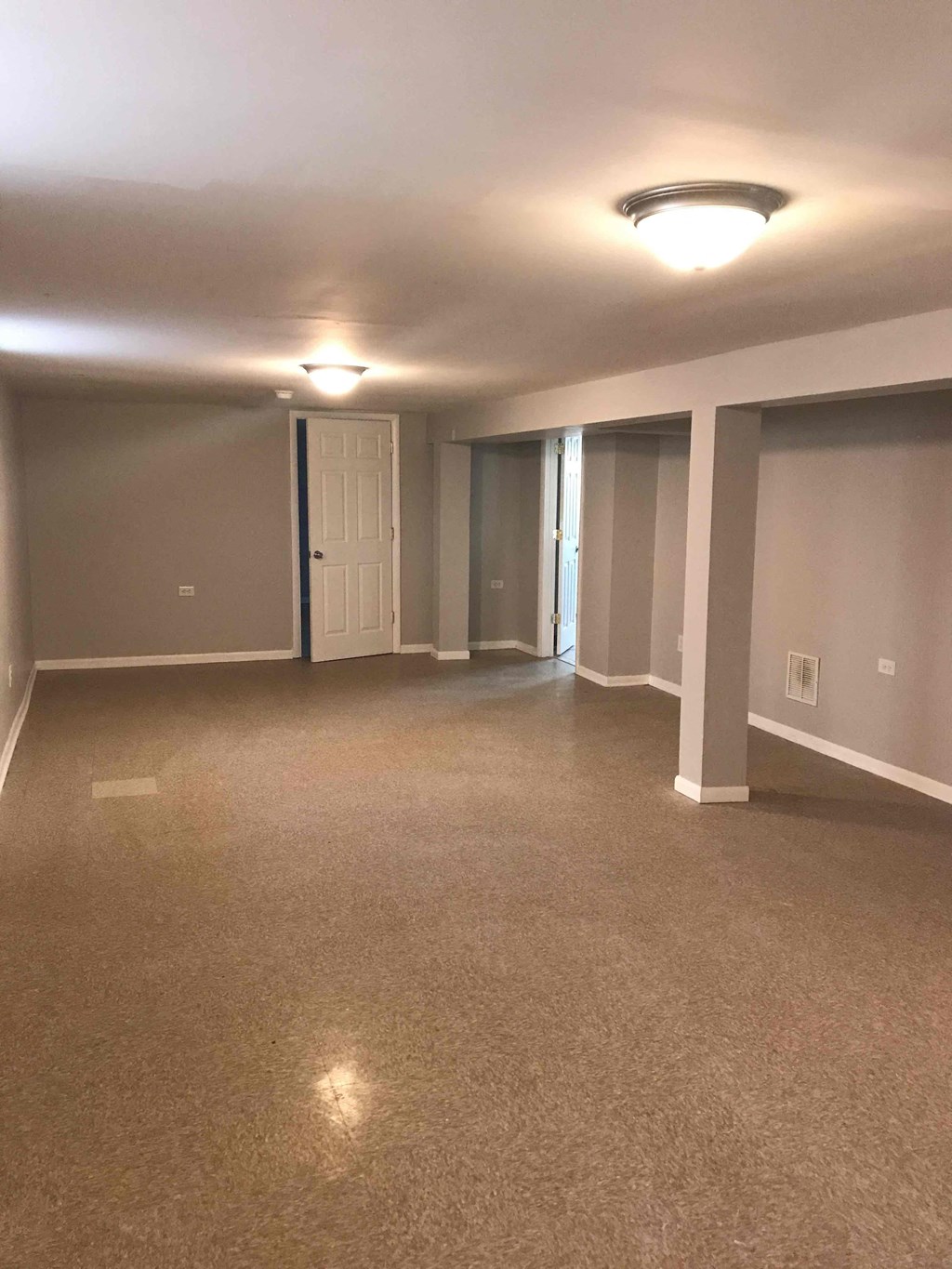 an empty living room with neutral walls and carpet