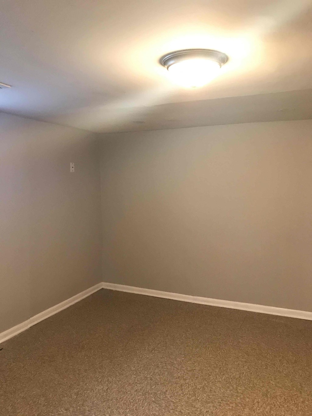 a empty room with white walls and a light on the ceiling