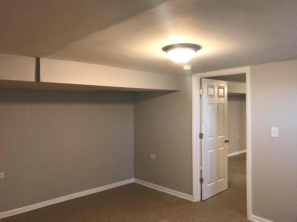 an empty room with a white door and a light on the ceiling