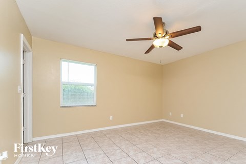 a living room with a ceiling fan and a tiled floor