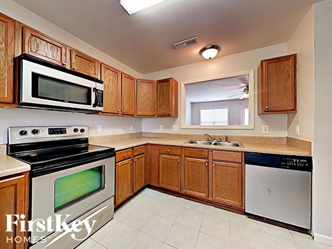 A kitchen with wooden cabinets and a stainless steel dishwasher.
