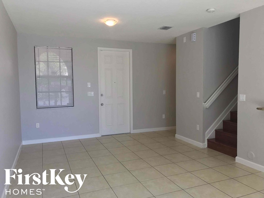 A spacious room with a staircase leading to the upper floor.