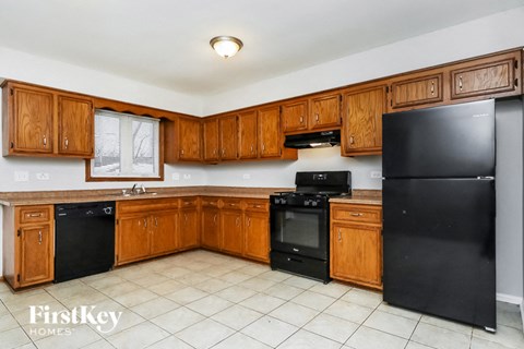A kitchen with wooden cabinets and black appliances.