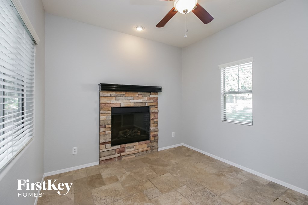 the living room has a brick fireplace and tile flooring