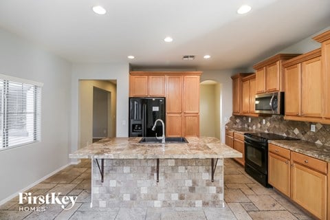 a large kitchen with granite counter tops and wooden cabinets