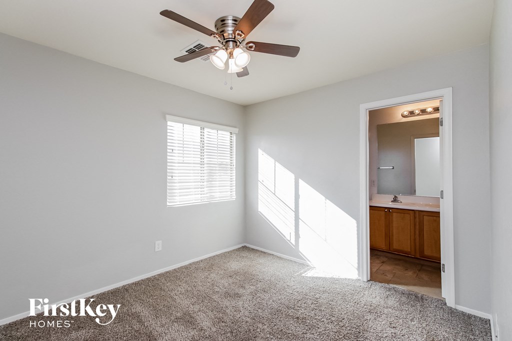 an empty room with a ceiling fan and a bathroom