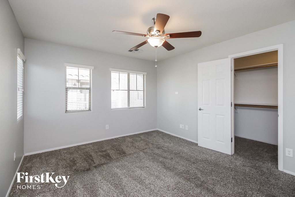 an empty room with a ceiling fan and a closet