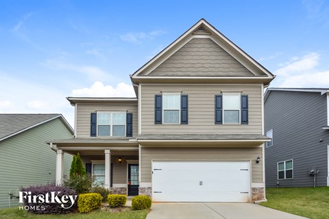 a tan house with a white garage door