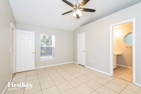 the living room has a ceiling fan and a tiled floor