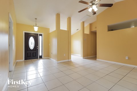 an empty living room with yellow walls and a tile floor