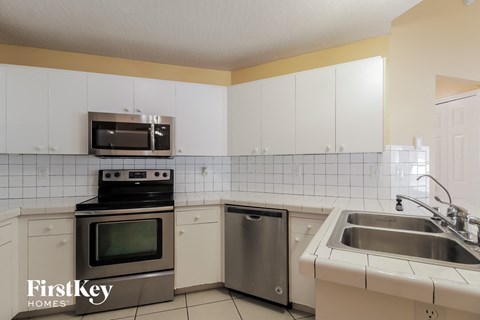 a kitchen with white cabinets and stainless steel appliances and a sink