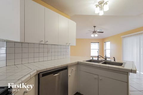 a kitchen with white cabinets and a sink and a dishwasher