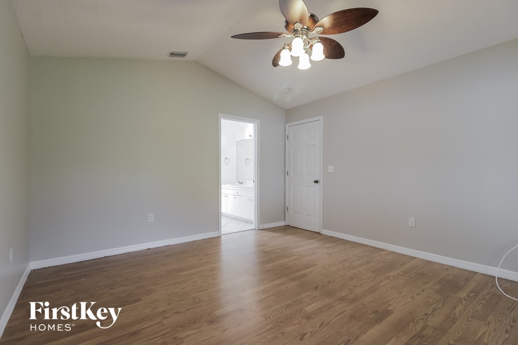 a living room with white walls and a ceiling fan