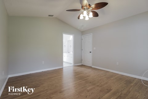 a living room with white walls and a ceiling fan
