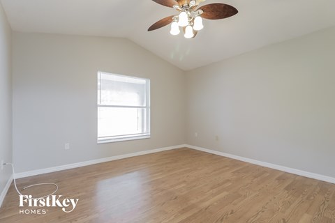 a bedroom with hardwood floors and a ceiling fan