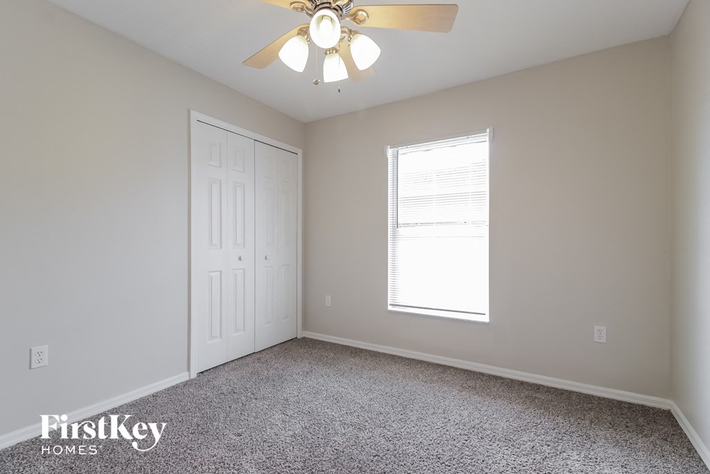 a bedroom with a ceiling fan and a window