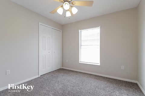 a bedroom with a ceiling fan and a window