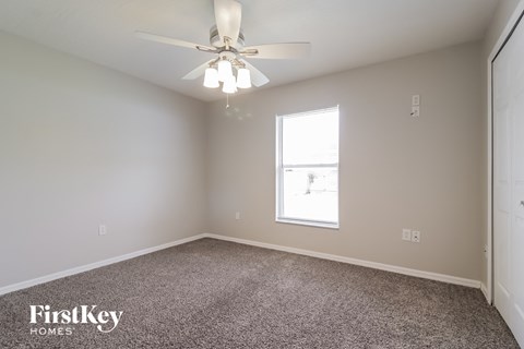a bedroom with a ceiling fan and a window