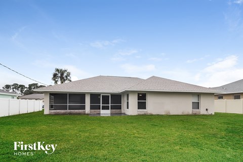 a house with a grassy yard and a white fence