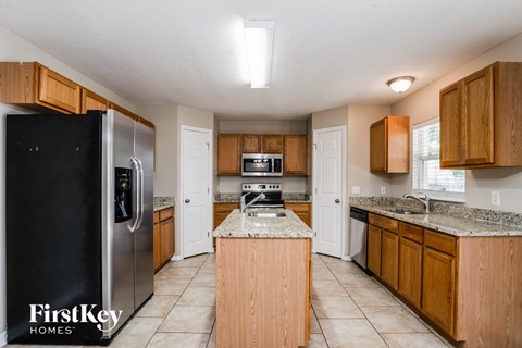 a kitchen with wooden cabinets and a stainless steel refrigerator