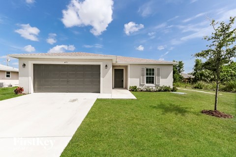 a white house with a lawn and a garage