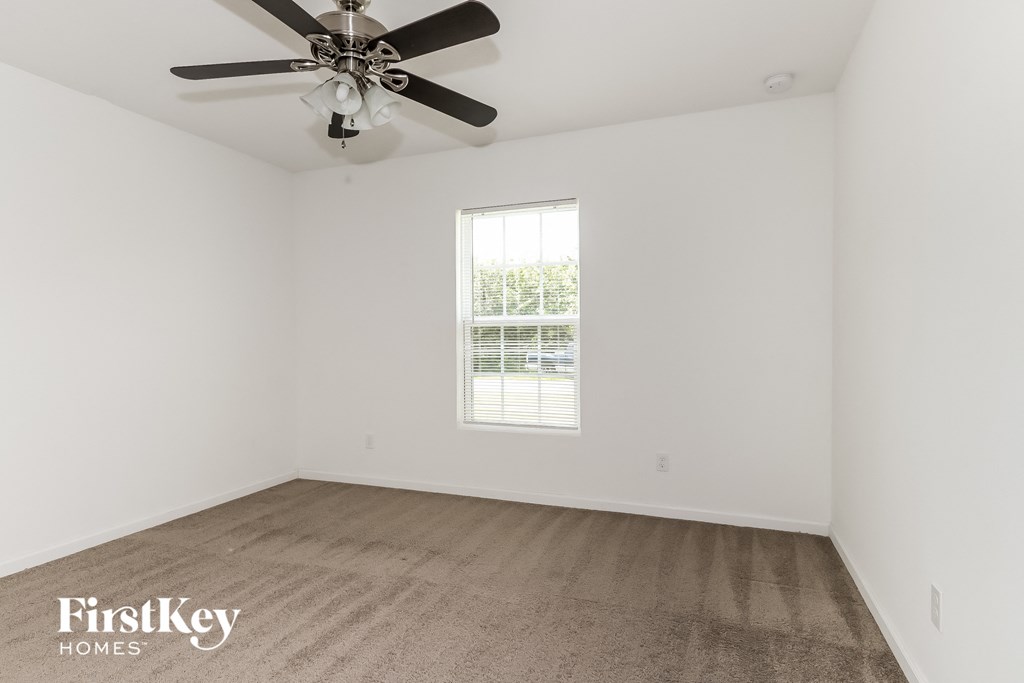 a white room with a ceiling fan and a window