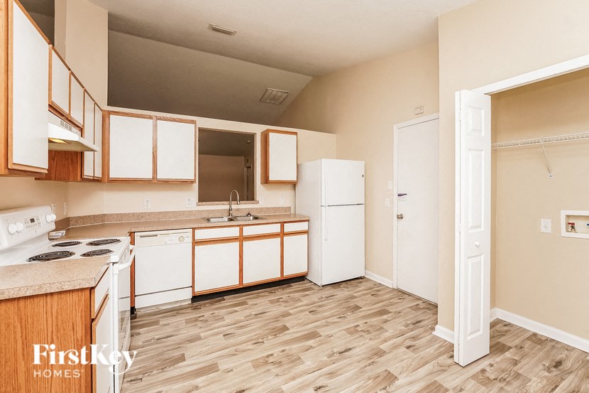 a kitchen with white appliances and wood flooring