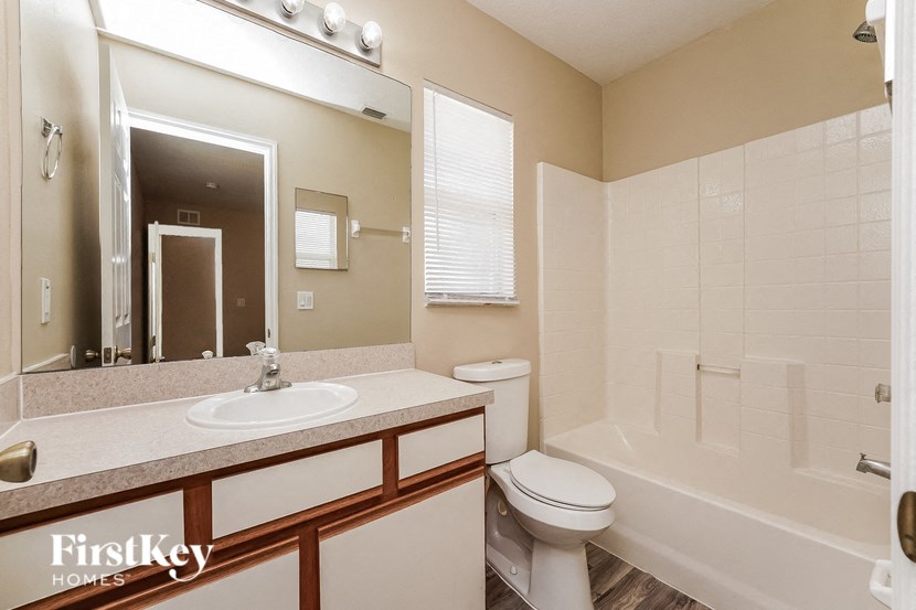 a bathroom with a shower toilet and sink and a mirror