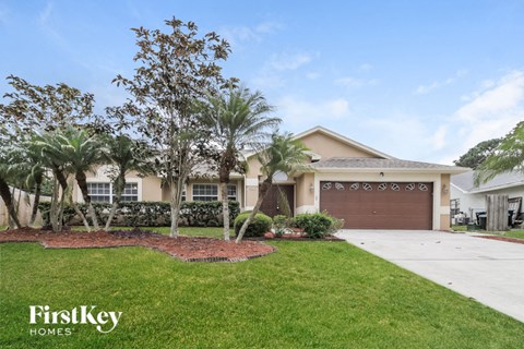 a house with palm trees in front of it and a driveway