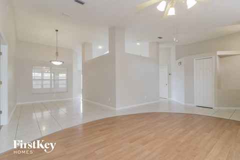 an empty living room with white walls and a wooden floor