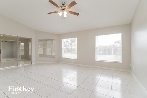 an empty living room with a ceiling fan