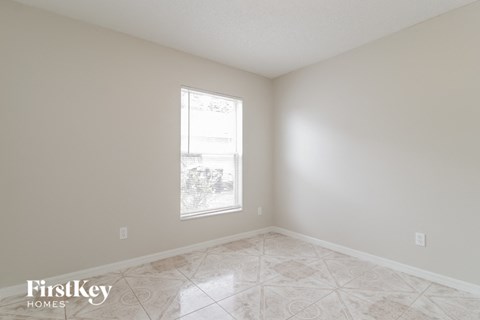 a empty room with a window and a tiled floor
