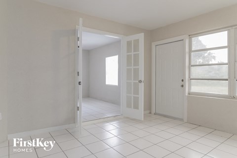 a room with a white tiled floor and an open door
