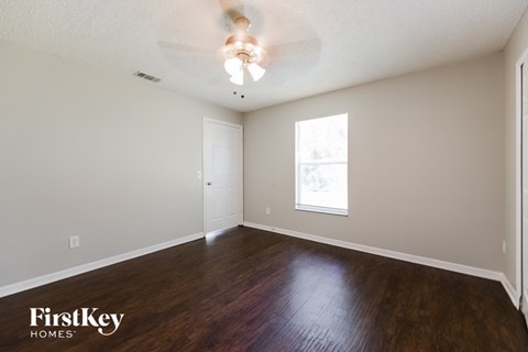 a living room with wood floors and a ceiling fan
