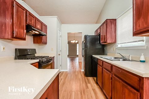 a kitchen with wooden cabinets and a black refrigerator