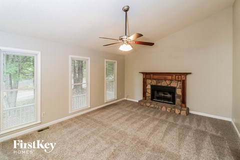 a living room with a fireplace and a ceiling fan