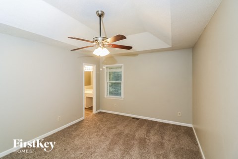 a bedroom with a ceiling fan and a carpeted floor