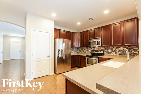 A kitchen with brown cabinets and a stainless steel refrigerator.