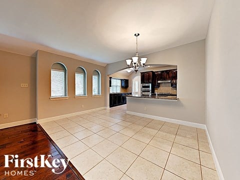 an open kitchen and living room with tile flooring