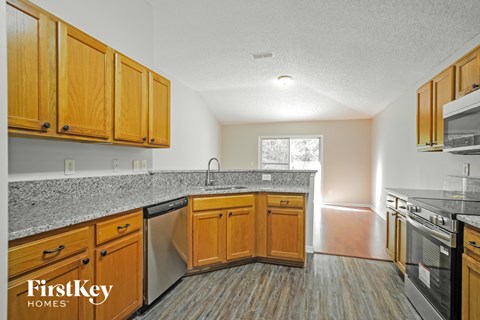A kitchen with wooden cabinets and a granite countertop.