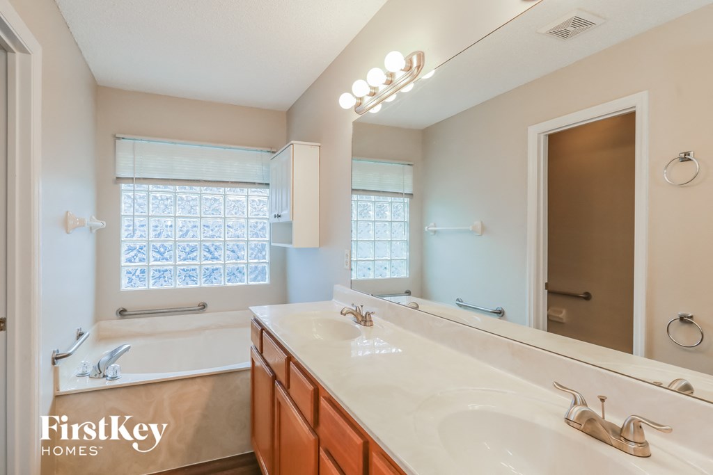 a bathroom with a sink and a tub and a mirror
